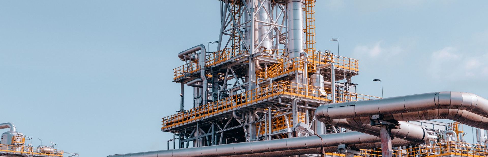 Process plant structure and pipework against a blue sky