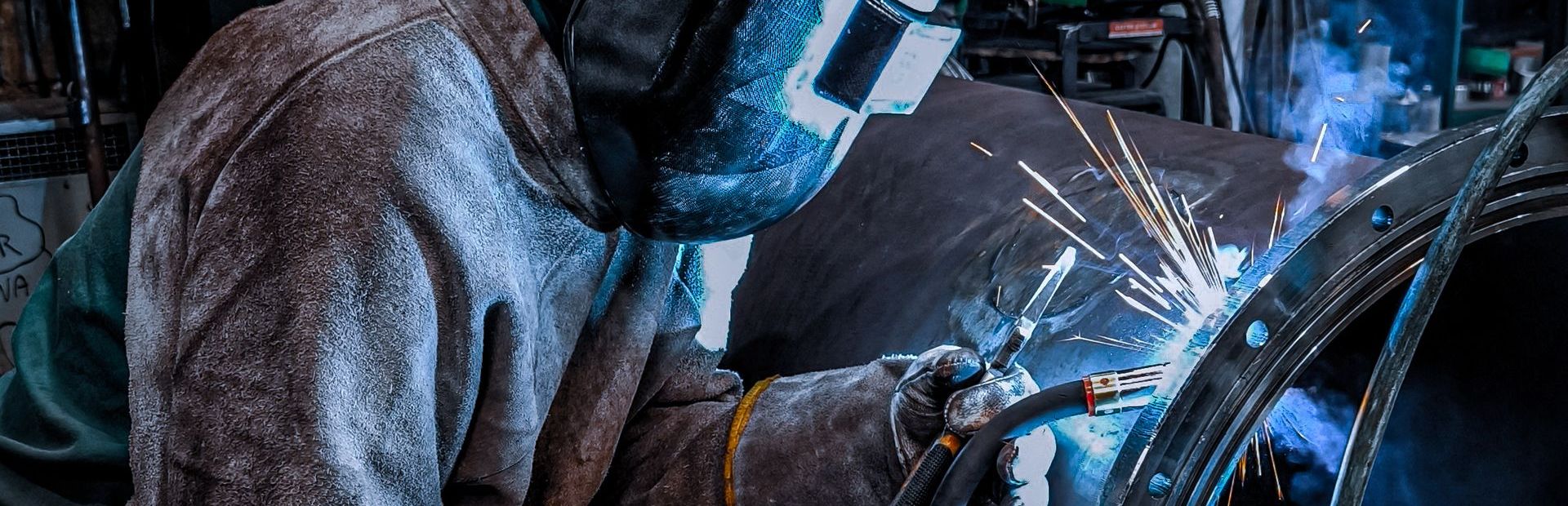 Welder working on a pipe flange joint